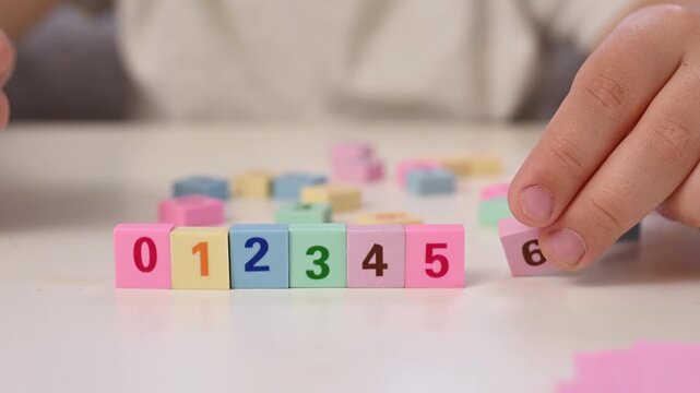 A boy adds numbers from 1 to 10 in sequence, learning to count, mathematics, arithmetic operations for children, early development, preparation for school hands close up