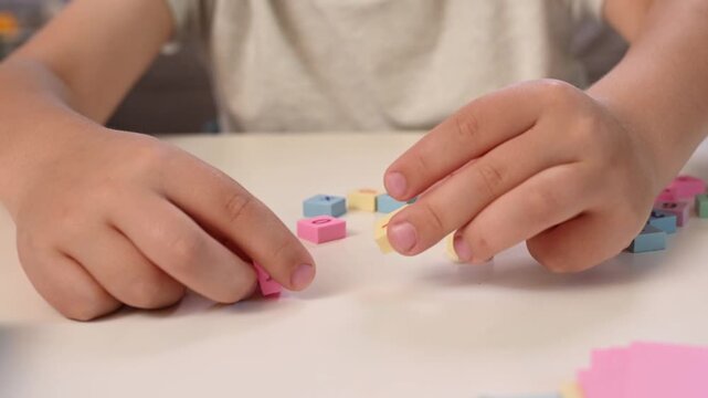 Close Up Child Learning Basic Addition with Colorful Math Blocks, Hand Placing Correct Answer During Early Mathematics Lesson, STEM Education, Homeschooling, Cognitive Development