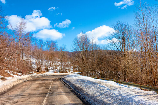 road through Carpathian mountain landscape in winter. travel countryside background. snow covered hills. sunny day