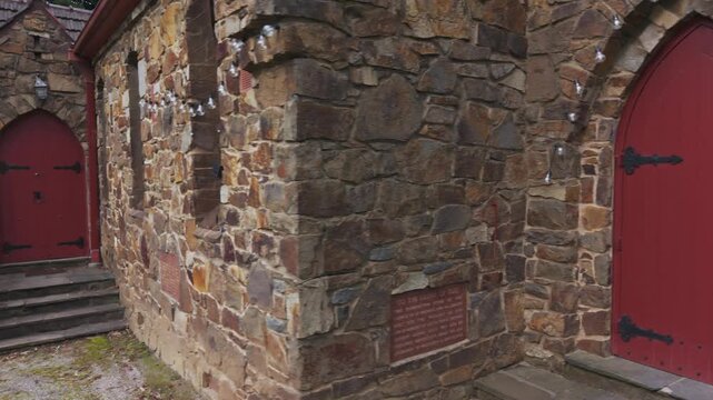 Stone church facade with red arched doors