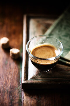 Coffee in glass cup on a dark wooden background. Soft focus. Close up. Copy space.