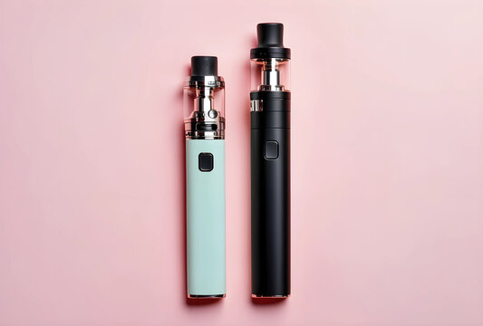 Two modern electronic cigarettes, one mint green and one black, standing upright on a soft pink background