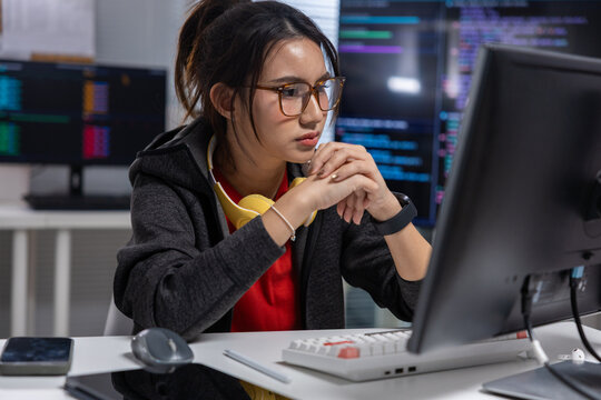 Programmer woman computer code office monitor glasses technology keyboard developer, focused young woman programmer working computer with code monitor modern office, glasses, keyboard, headset