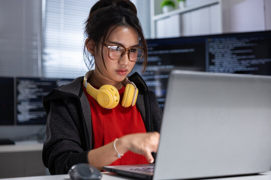 Programmer woman laptop headphone office code screen technology developer computer, focused woman programmer with yellow headphone working laptop modern office with code screen and technology