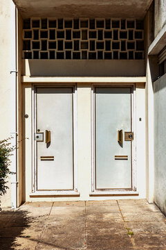 Two Plain Doors With Square Design Above in Bright Sunlight