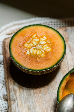 Freshly Cut Melon on Wooden Board With Spoon Beside