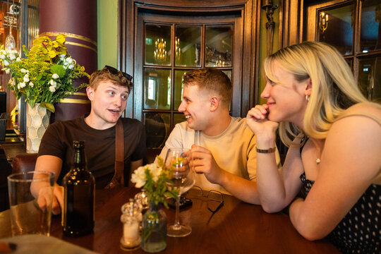 Friends enjoying drinks and conversation in London pub