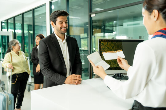 A passenger communicates with an airport representative during check-in illustrating hospitality customer care and professional support before departure.