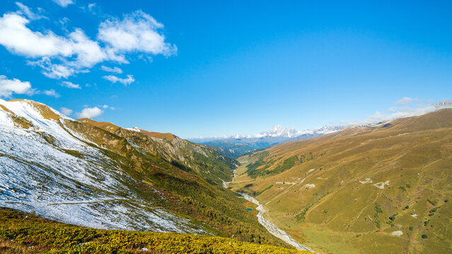 Landscape photograph of Adishi valley viewed from Chkhutnieri pass towards Adishi village in Svaneti Georgia.
