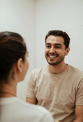 Fototapeta premium Smiling young adult man with a beard looking at a woman, communication and connection concept, positive interaction