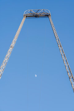 Blackpool, UK &ndash; May 24, 2026: Tall amusement ride frame beneath moon and clear blue sky