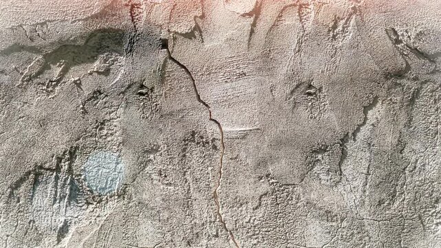 Seamless 4K looping vertical movement over an aged concrete wall with rough plaster and weathered details. Ideal for grunge backgrounds and construction themed visuals.