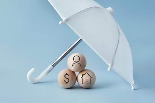 Umbrella protecting home, person and money symbols. Financial security and insurance concept