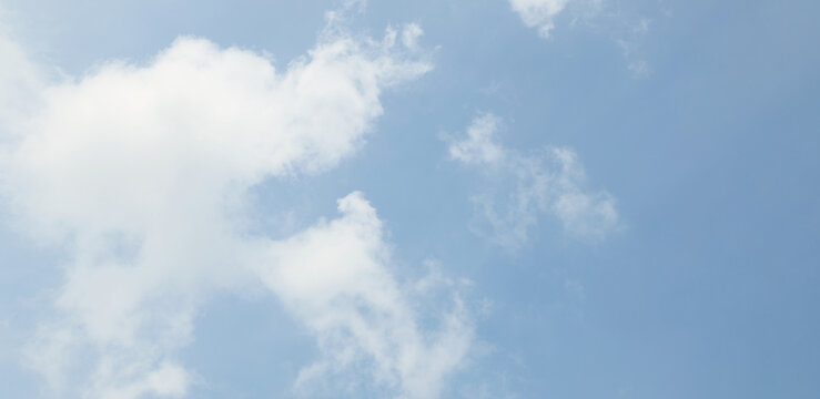 A clear blue sky with soft white clouds