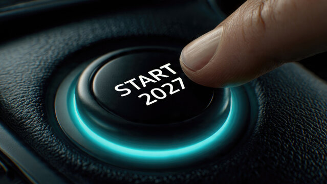 Finger pressing start button with year 2027 illuminated in a car interior