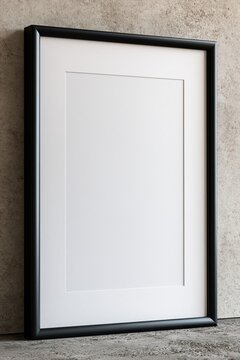 Empty black picture frame with white matting on textured concrete background, ready for art or photography display