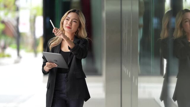 Confident businesswoman holding a tablet and stylus, emphasizing precision and adaptability in a contemporary workspace, blending style and functionality.