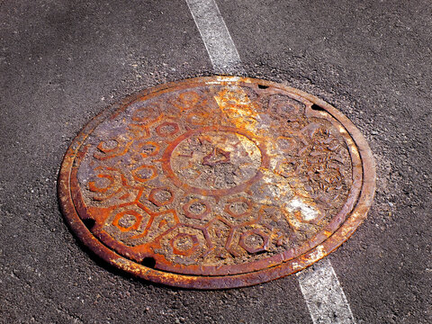 Manhole Cover Man Hole Iron Round Cover Worn and Rusty with White Painted Line Slanted and Off Kilter