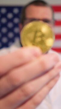 Pharmacist in lab coat holding prescription pill bottle, cash, and crypto against an American flag, symbolizing the influence of money on US medicine