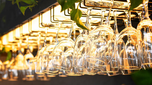Clean Wine Glasses Hanging Above Bar Counter Close Up