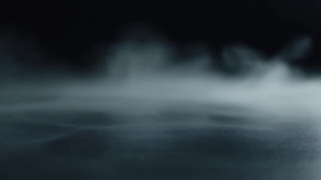Cool silver mist disperses and thins across dark surface, soft wisps fading gradually under cool backlighting with ethereal atmosphere, subtle glow, and minimalist cinematic motion.