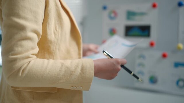 Business Professional Reviewing Charts During Office Presentation