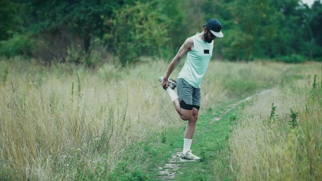 Runner Stretching Leg Muscles Before Workout. Trail Field Training 