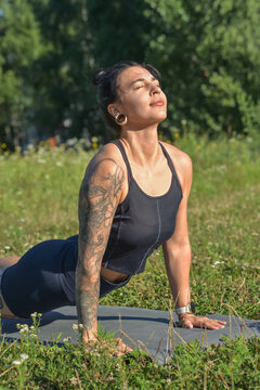 Young woman practicing Surya Namaskar yoga outdoors