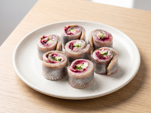 Herring rollmops filled with beetroot and cucumber served on a plate