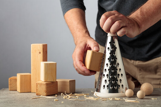 Man grating wooden blocks into round shapes, illustrating pointless work, wasted effort and an inefficient process.