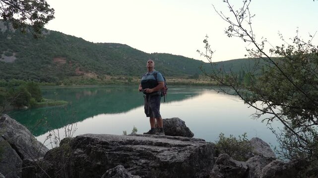 Hiker recording a video with the phone on the rock.