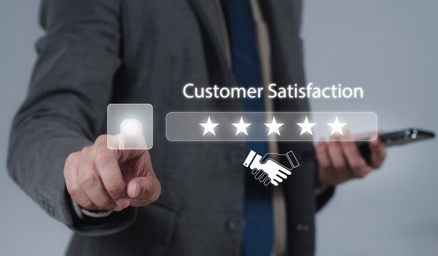 The hand is giving a five-star rating. The business person selects the smiley face icon on the virtual screen to express their satisfaction with the service. The rating received is very impressive.
