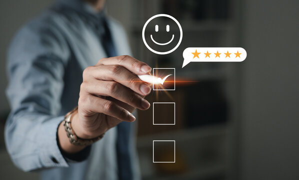 The hand is giving a five-star rating. The business person selects the smiley face icon on the virtual screen to express their satisfaction with the service. The rating received is very impressive.