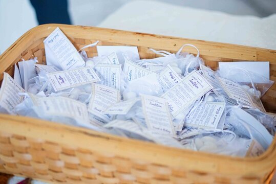 wedding favors gathered in basket indoor close-up white blue brown celebratory tags sweets naturals.