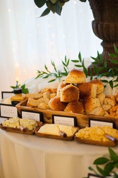 elegant bread and butter station arrangement indoor event space close-up brown white yellow green.a.