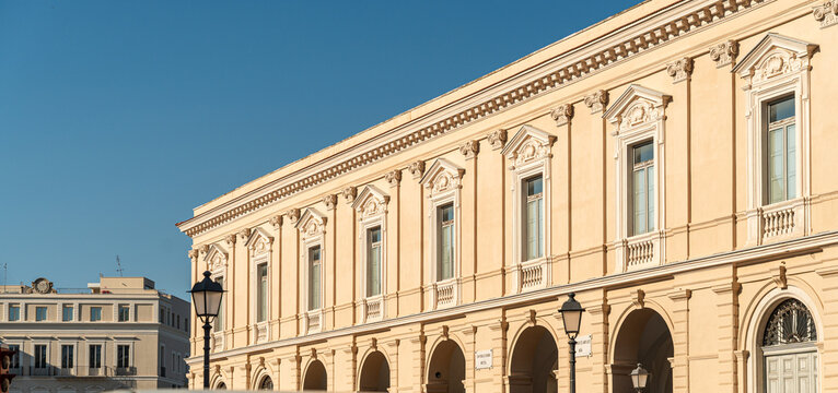 Bari Italy neoclassical palace facade with arched portico and ornate pilasters along sunlit historic city center square, concept of Mediterranean architecture and cultural heritage