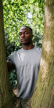 Young man posing between trees in nature