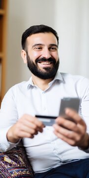 Happy man shopping online holding phone and credit card