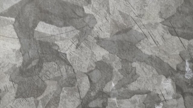 Close-up of hot-dip galvanized steel sheet surface showing distinct zinc spangle texture, gray metallic pattern, and industrial crystal flake structures.