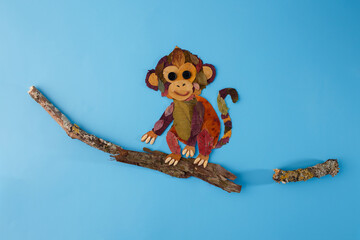 Fall leaf monkey art project with scissors on pink table useful for children book publisher, stationery brand, creative studio, parenting blog, © Elena