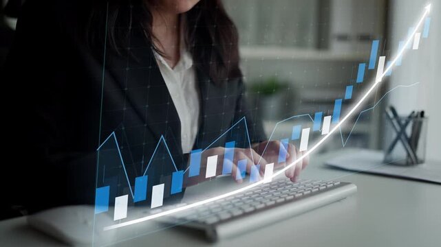 A business professional engages in financial data analysis at a modern office, combining keyboard input with dynamic data visualization on screen. Copula
