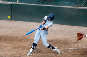 Obraz premium Softball Player Batting Swinging Hitting Playing Fast Pitch Baseball Action Sports