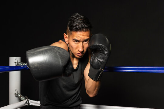 Powerful Hispanic boxer throwing right straight punch toward camera