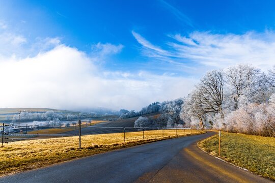 Scenic country road winding through a frosty winter landscape