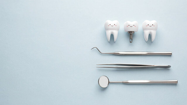 Dental implant and teeth models with professional metal dental tools on blue background
