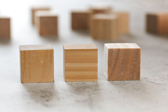 Three wooden cubes, more blurred in background