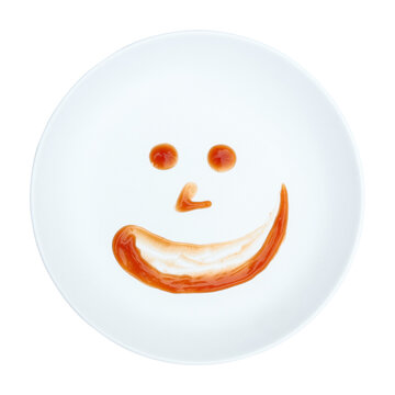 red chili sauce decoration like human face on white circle plate isolated on white.
