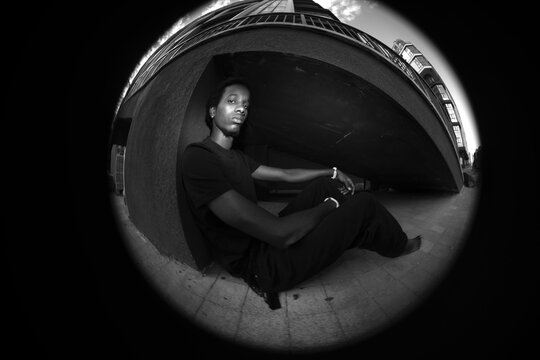 Circular fisheye black and white urban portrait of man with concrete copy space