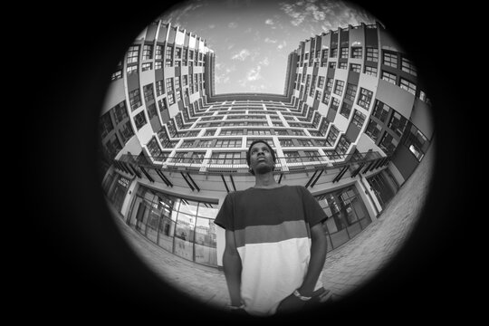 Circular fisheye black and white urban portrait of man with architecture copy space