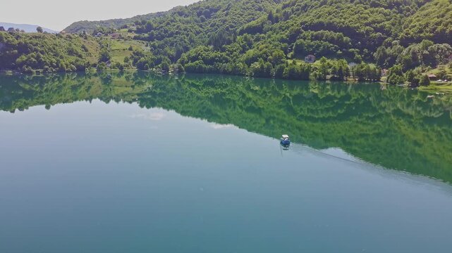 Aerial Drone View of Pliva Lake in Bosnia and Herzegovina with Emerald Green Water and Mountain Reflections